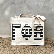 Model carrying the Gamma Phi Beta small black and white stripe tote.
