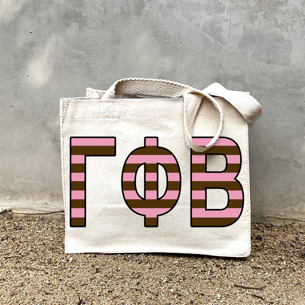 Model carrying the Gamma Phi Beta Greek letters in sorority colors small striped tote.