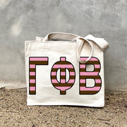 Model carrying the Gamma Phi Beta Greek letters in sorority colors small striped tote.