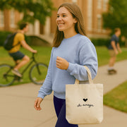 Chi Omega tote bag with XO Greek letters and heart design, shown at a casual lunch on campus.