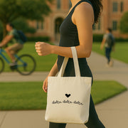 Delta Delta Delta Greek letters with heart printed on a canvas tote bag used for a Big/Little reveal.