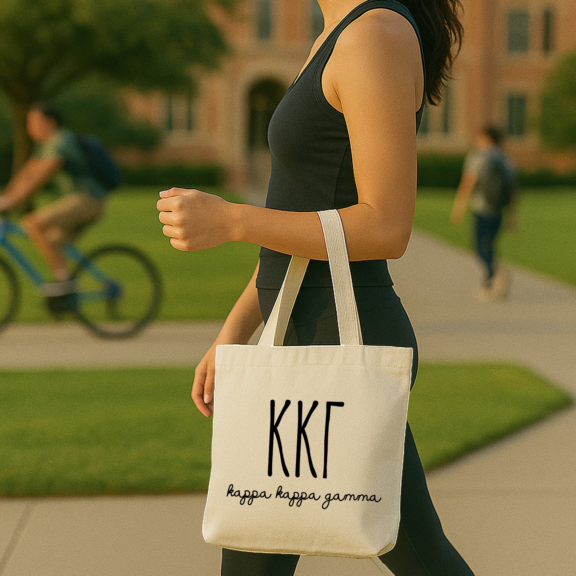 College student carrying a Kappa Kappa Gamma small canvas tote bag with striped Greek letters