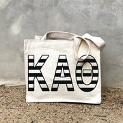 KAT Black Stripe Tote in front of a gray wall