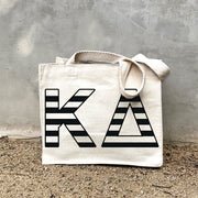 KD Black Stripe Tote in front of a gray wall