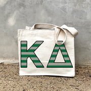 KD Black Stripe Tote in front of a gray wall