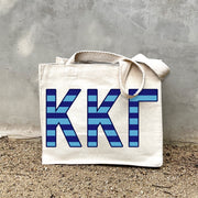 Model carrying the Kappa Kappa Gamma Greek letters in sorority colors small striped tote.