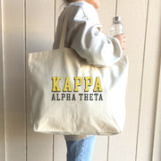 Kappa Alpha Theta tote featuring a bold raised name design, carried over the shoulder by a stylish student.
