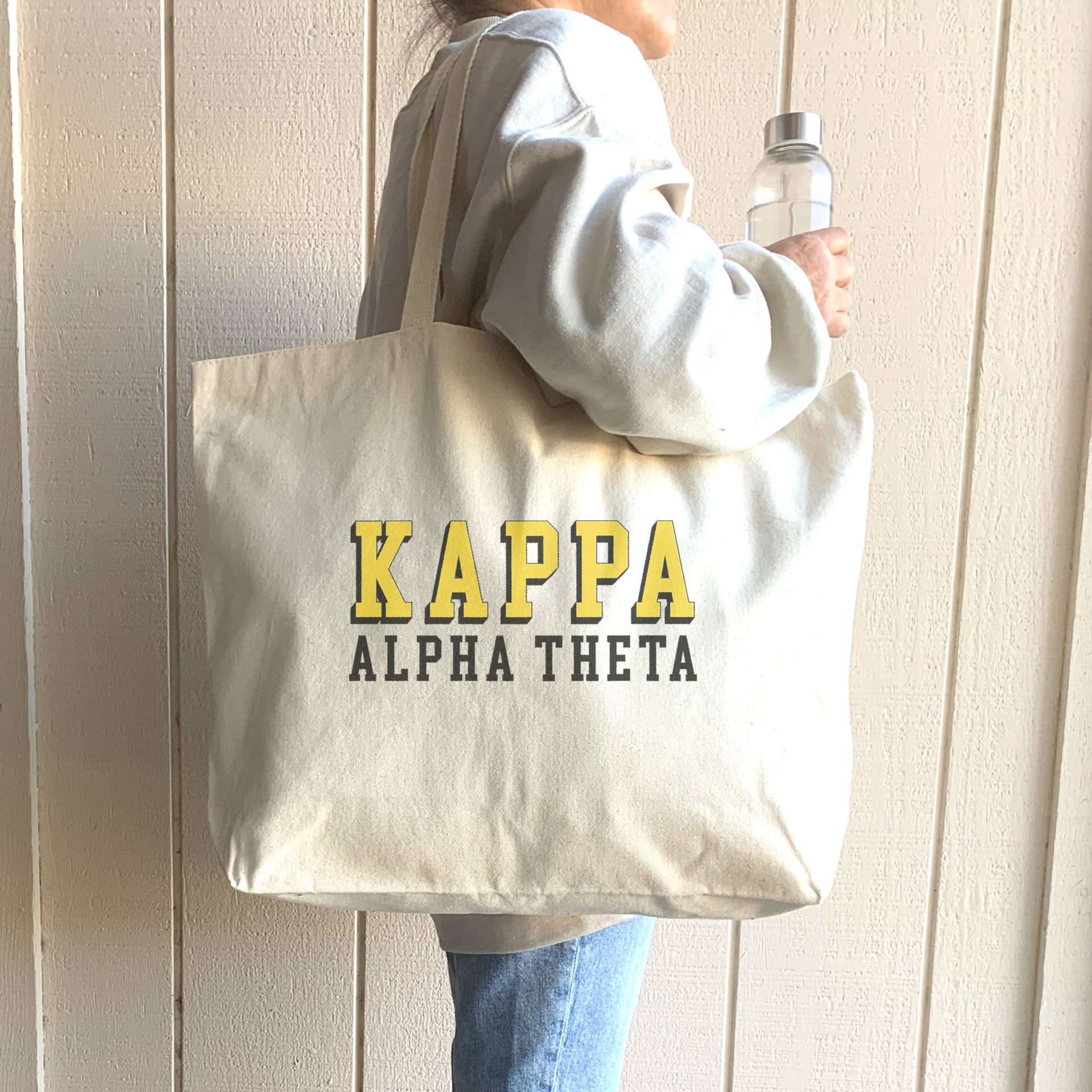 Kappa Alpha Theta tote featuring a bold raised name design, carried over the shoulder by a stylish student.