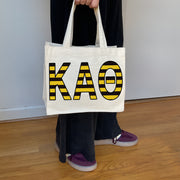 Model carrying the Kappa Alpha Theta Greek letters in sorority colors small striped tote.