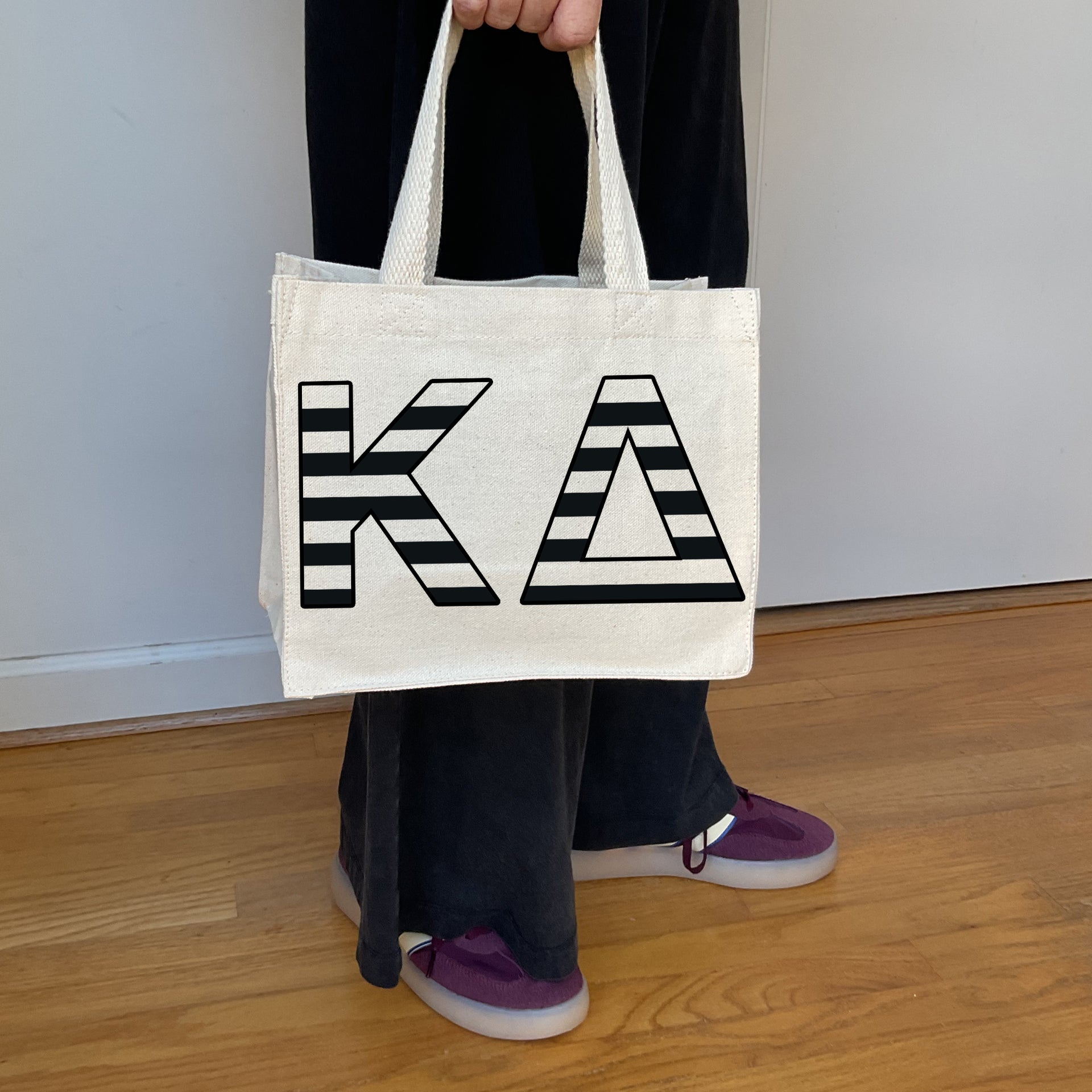 Model carrying the Kappa Delta small black and white stripe tote.