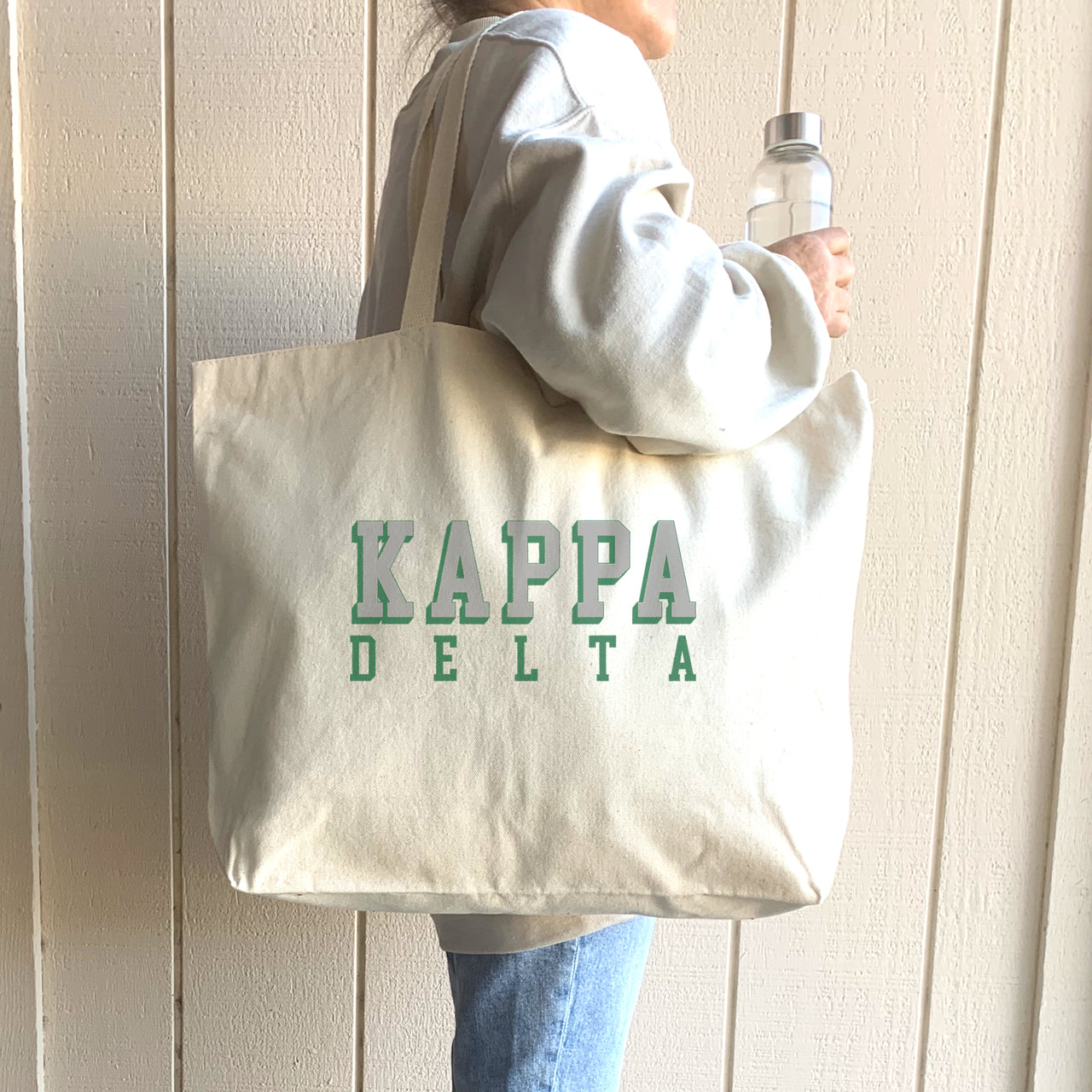 Kappa Delta sorority tote with 3D text, worn over the shoulder of a Kappa Delta member on campus.