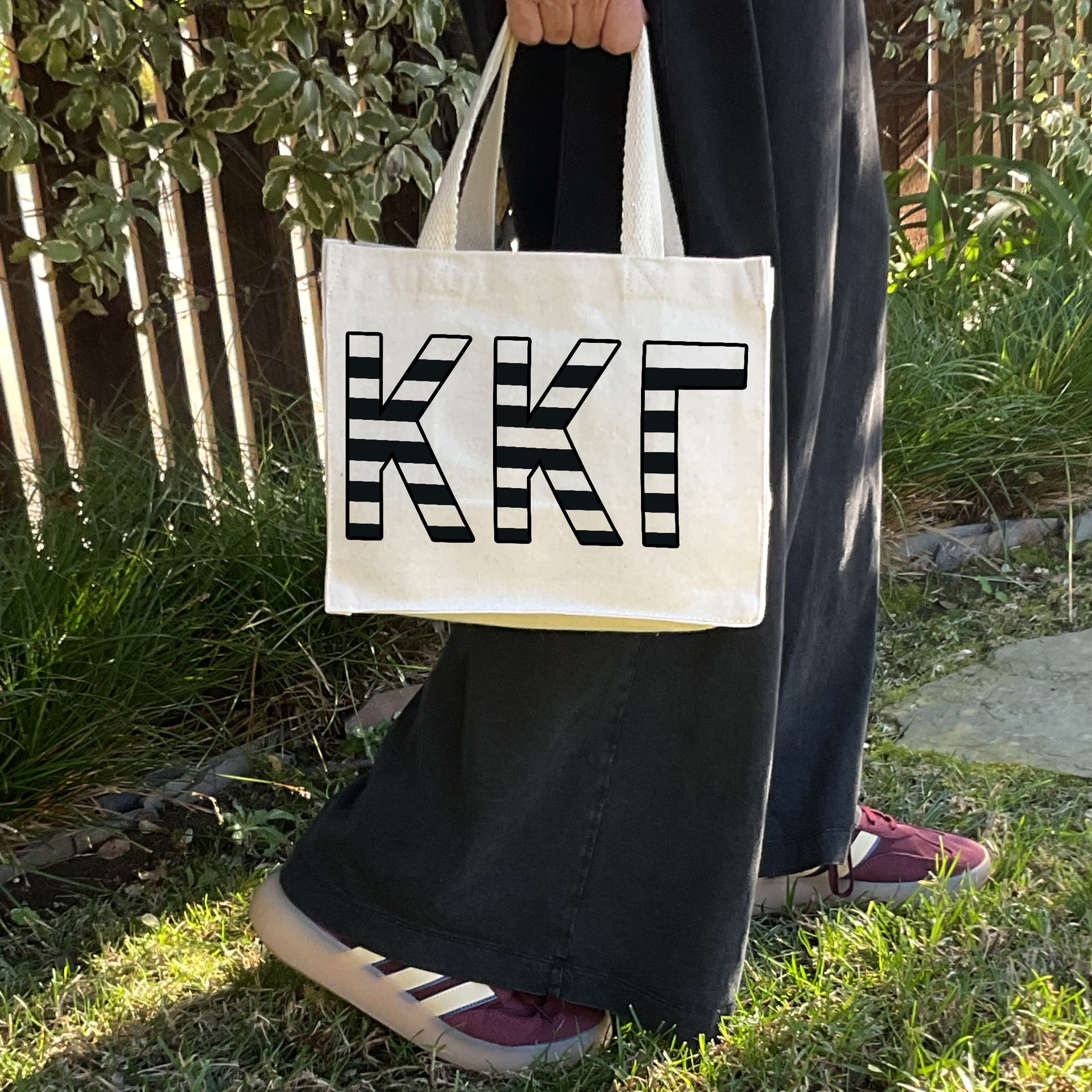 Model carrying the Kappa Alpha Theta small black and white stripe tote.