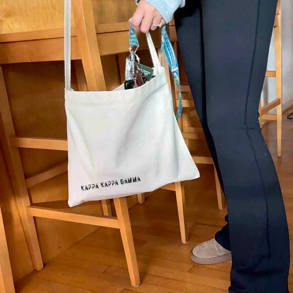 Crafted from durable canvas, each spacious bag features the Kappa Kappa Gamma name digitally printed on both sides in the lower corner.
