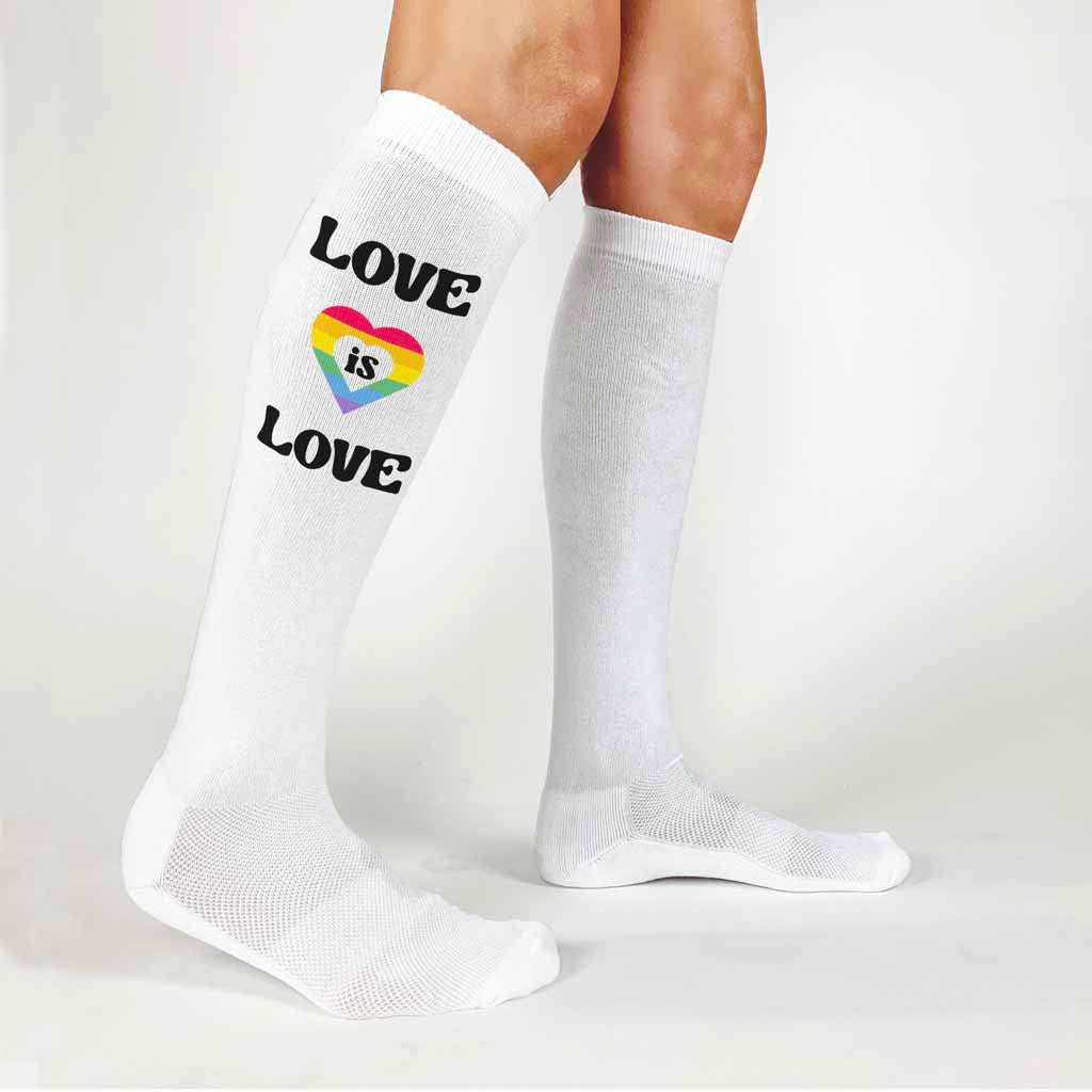 Comfortable white cotton knee high socks digitally printed with love is love rainbow heart design to show love wins and support the pride parade. 