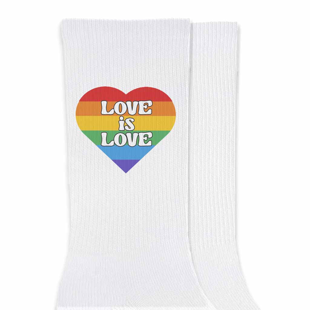 Love is love rainbow heart design digitally printed on the outside of white cotton crew socks are the perfect accessory for your pride supporting friends.