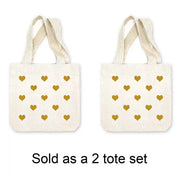 Mini canvas tote bags with all over heart design digitally printed in the color of your choice sold in a pack of four. 