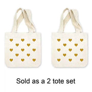 Mini canvas tote bags with all over heart design digitally printed in the color of your choice sold in a pack of four. 
