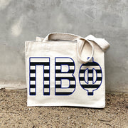 PBP Black Stripe Tote in front of a gray wall