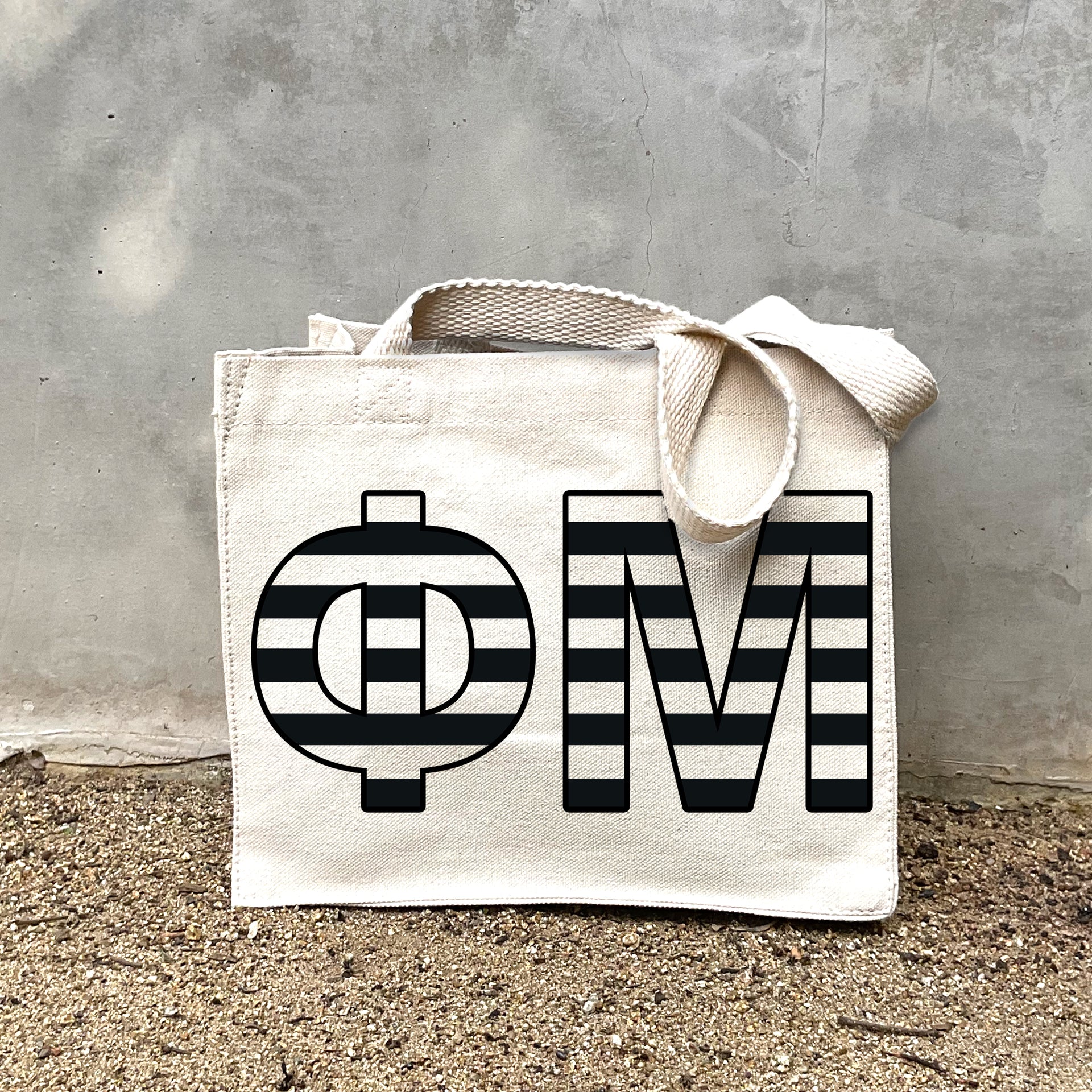 Model carrying the Phi Mu small black and white stripe tote.