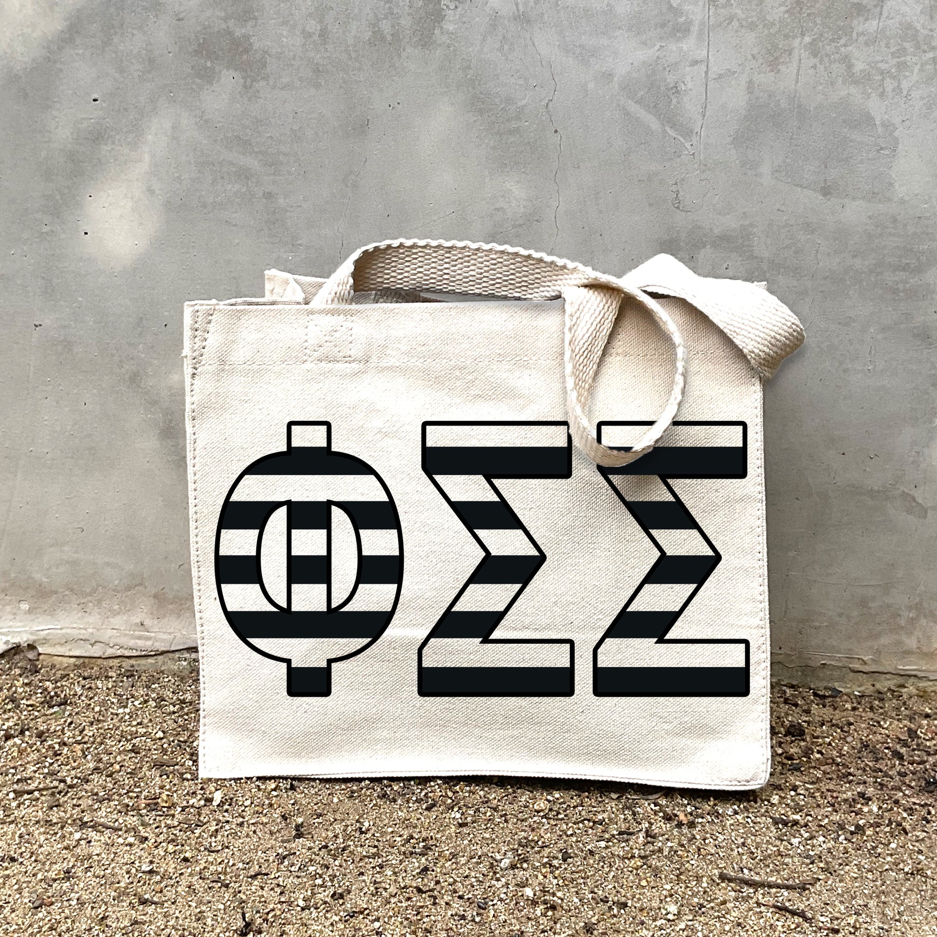 PSS Black Stripe Tote in front of a gray wall