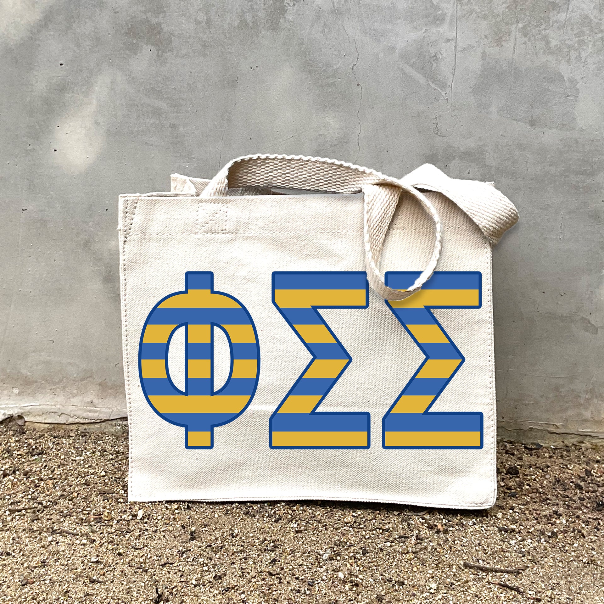 Model carrying the Phi Sigma Sigma Greek letters in sorority colors small striped tote.