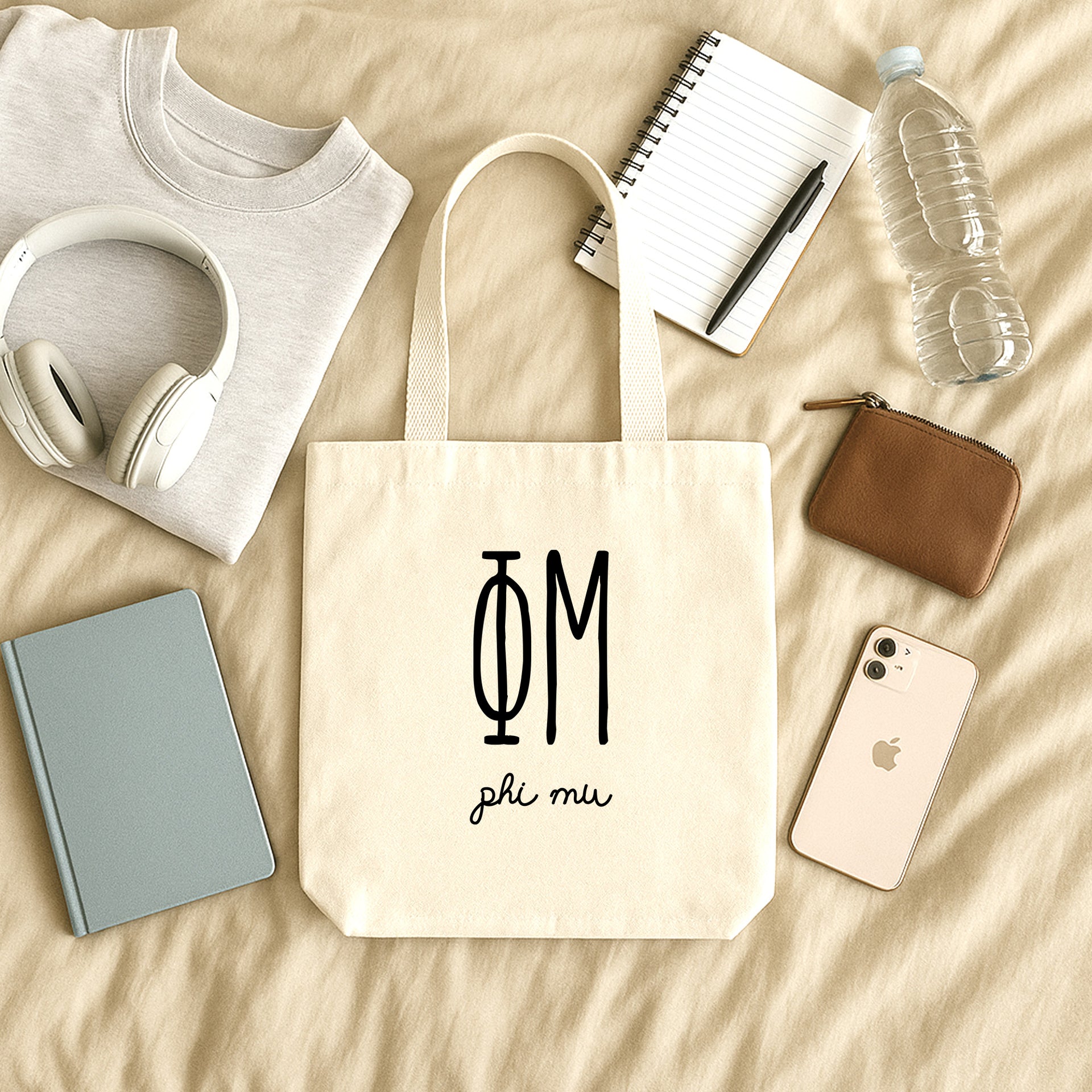College student carrying a Phi Mu small canvas tote bag with striped Greek letters