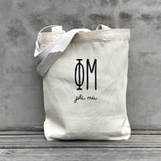 Phi Mu lifestyle image of a Phi Mu tote bag hanging on a dorm door, styled with the sorority’s name in retro font.