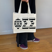Model carrying the Phi Sigma Sigma small black and white stripe tote.