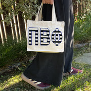 Model carrying the Pi Beta Phi small black and white stripe tote.