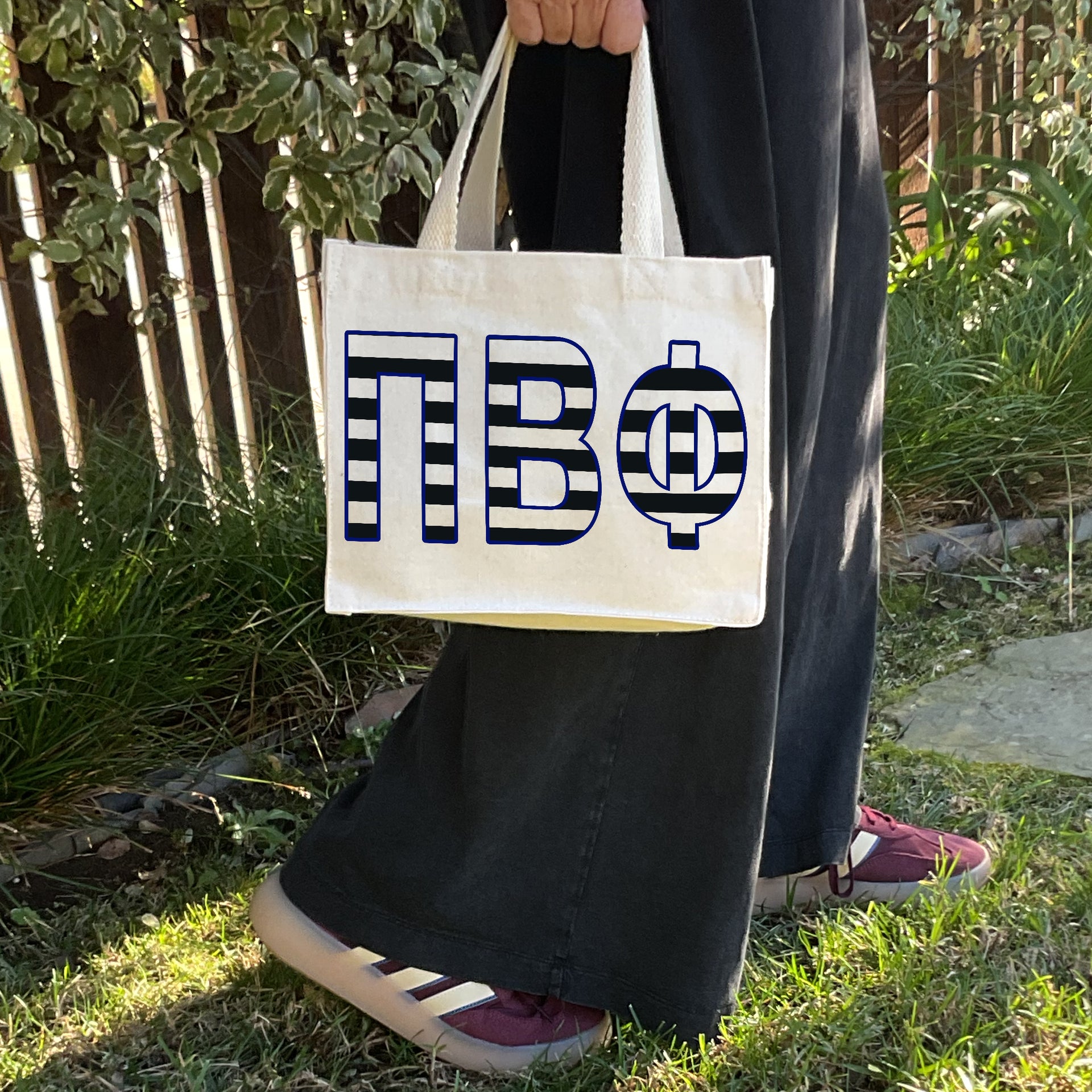 Model carrying the Pi Beta Phi small black and white stripe tote.
