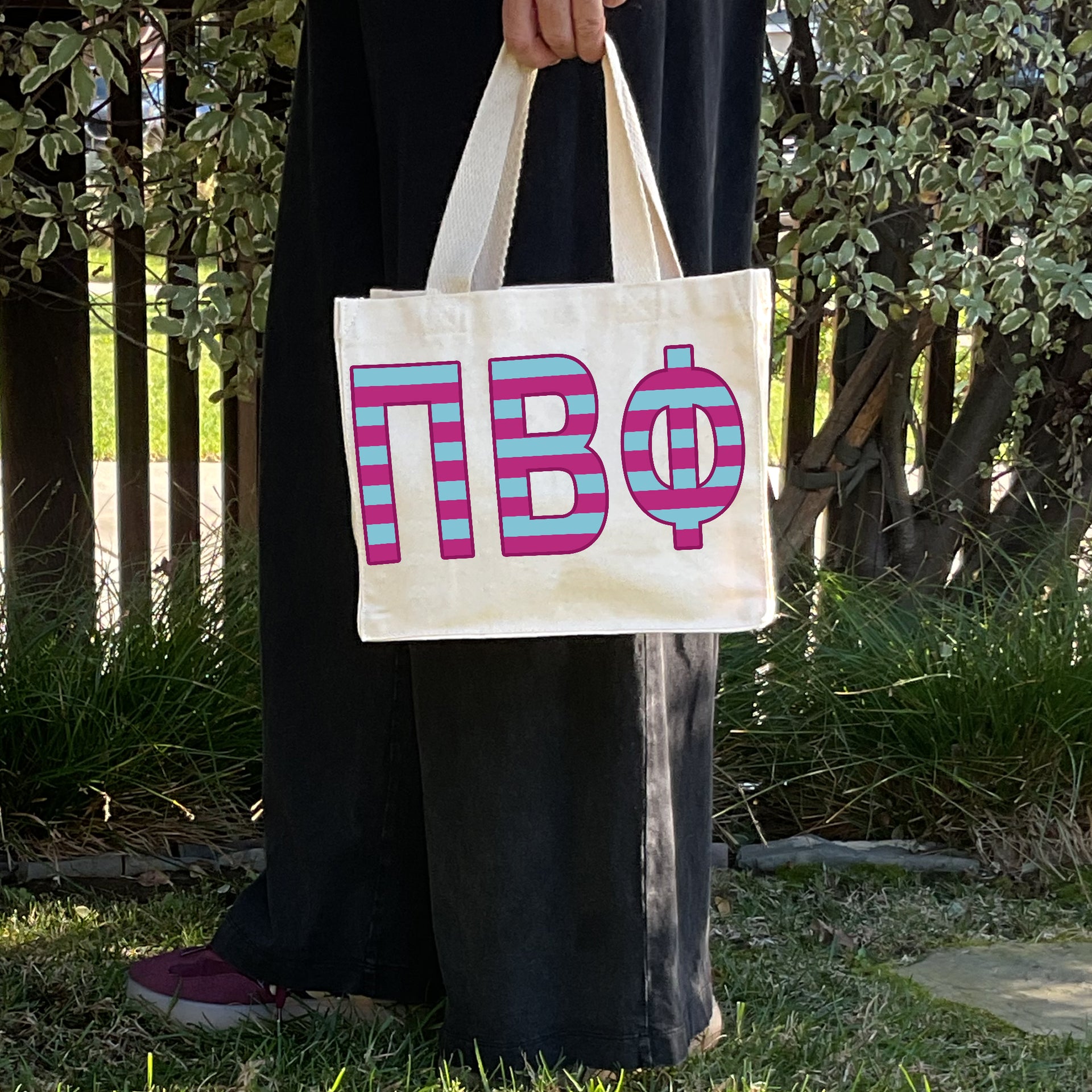 Model carrying the Pi Beta Phi Greek letters in sorority colors small striped tote.