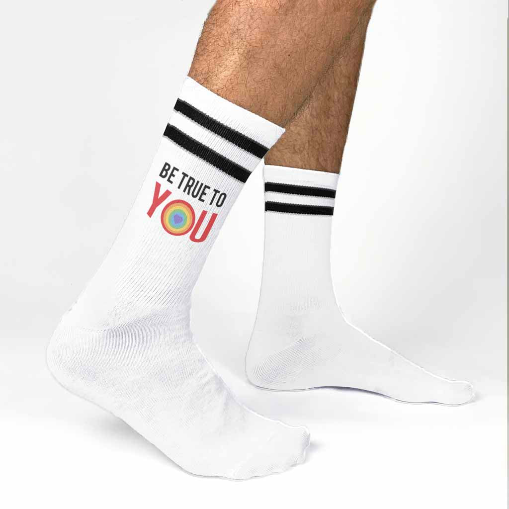 Custom printed be true to you LGBTQ rainbow heart design digitally printed on white cotton crew socks with black stripes.