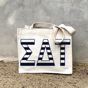 SDT Black Stripe Tote in front of a gray wall