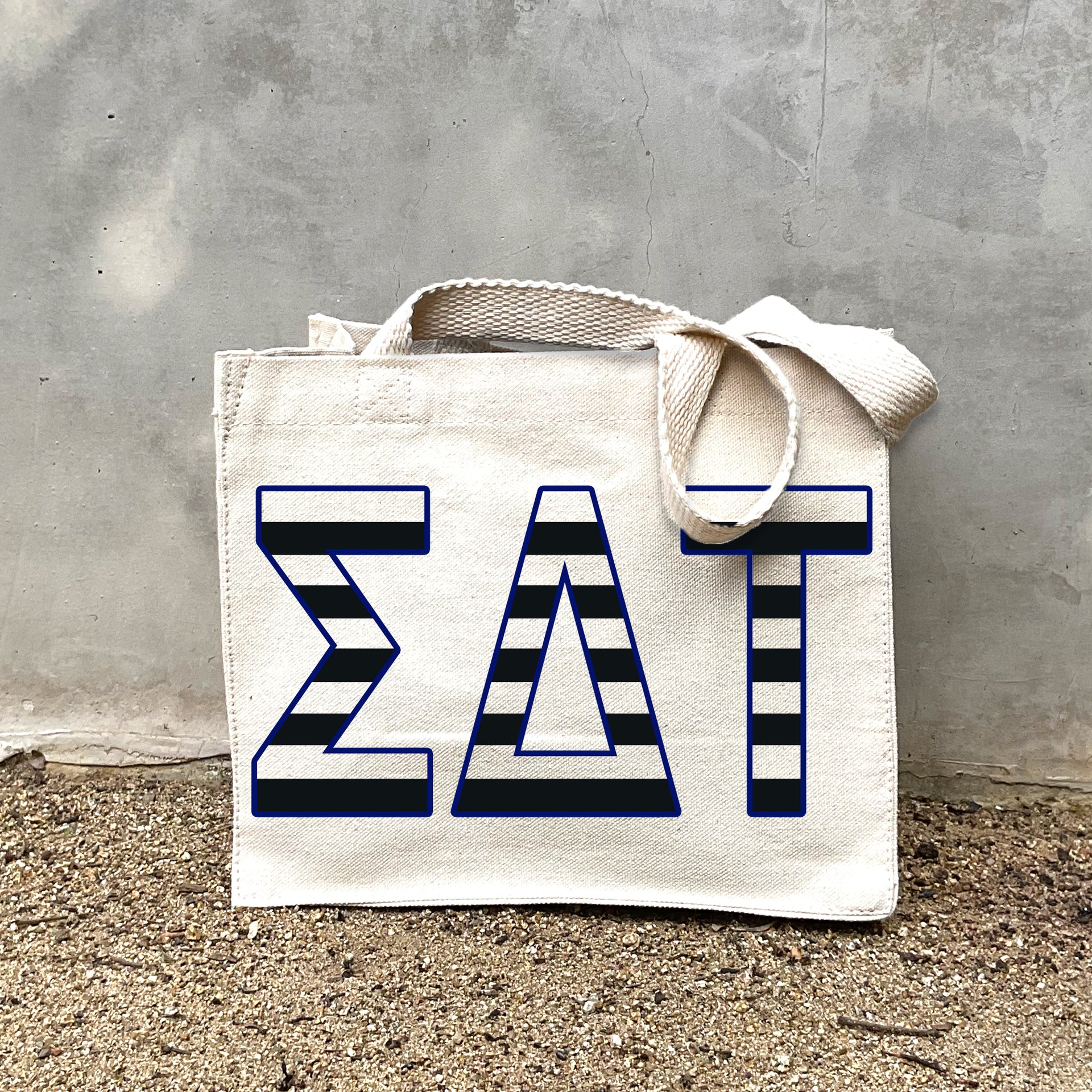 SDT Black Stripe Tote in front of a gray wall