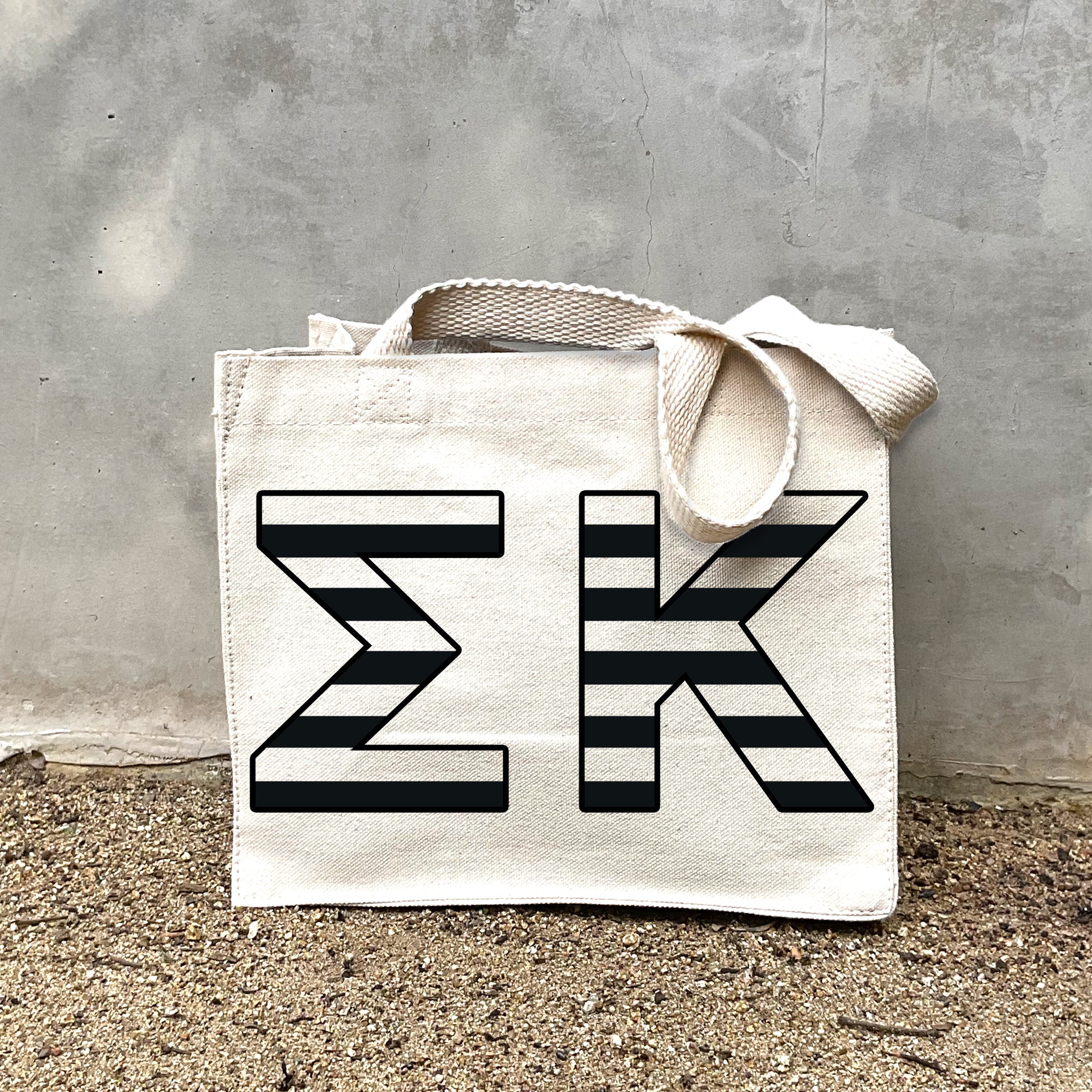 Model carrying the Sigma Kappa small black and white stripe tote.