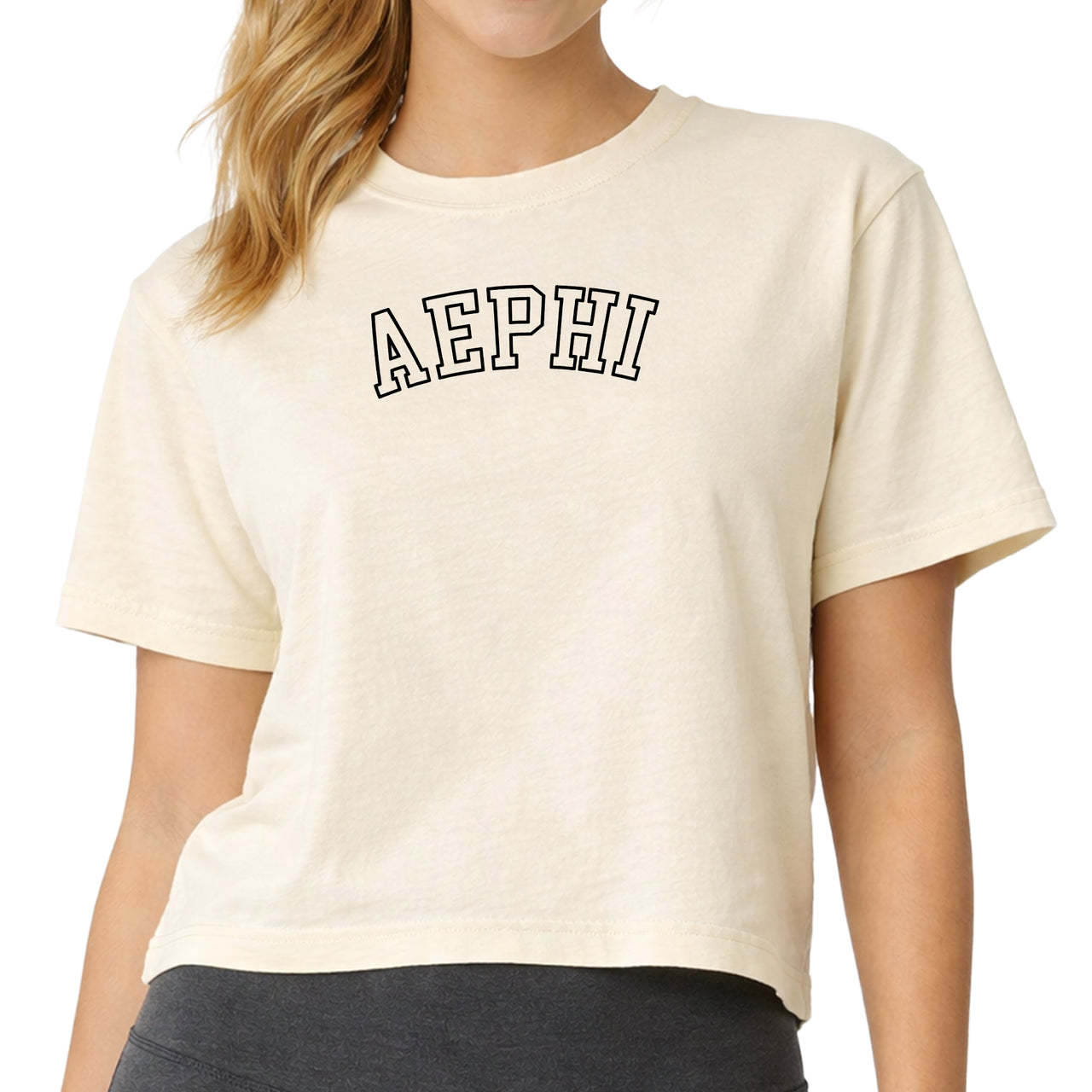 Woman wearing an Alpha Epsilon Phi Comfort Colors boxy crop t-shirt featuring the sorority name in block letters 