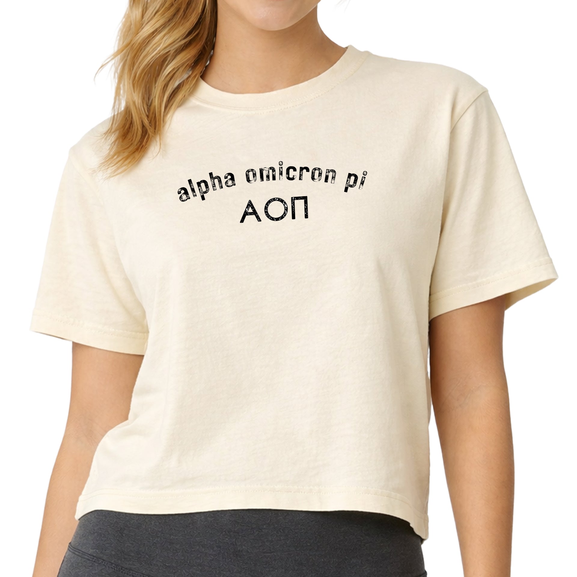 Woman wearing an Alpha Omicron Pi Comfort Colors boxy crop t-shirt featuring the sorority name and Greek letters design