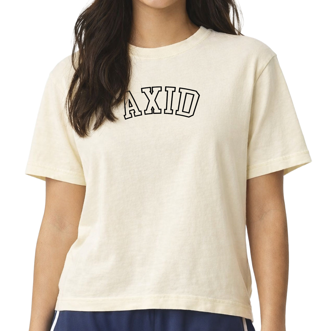 Woman wearing an Alpha Xi Delta Comfort Colors boxy crop t-shirt featuring the sorority name in block letters 