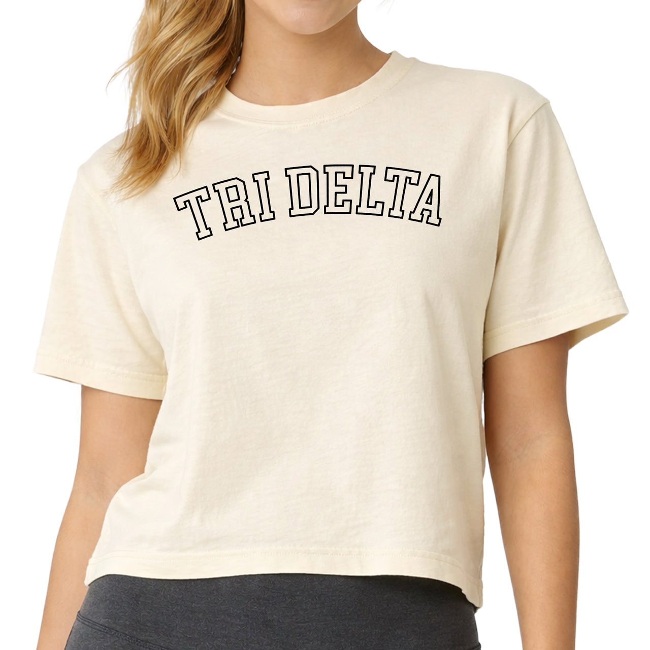 Woman wearing a Delta Delta Delta Comfort Colors boxy crop t-shirt featuring the sorority name in block letters 