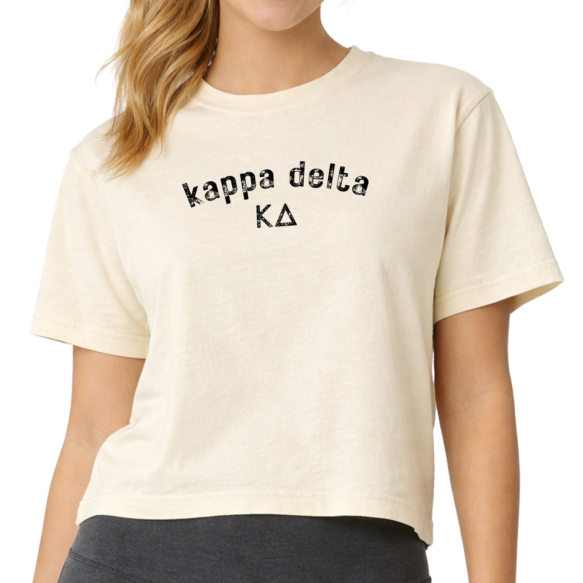Woman wearing a Kappa Delta Comfort Colors boxy crop t-shirt featuring the sorority name and Greek letters design