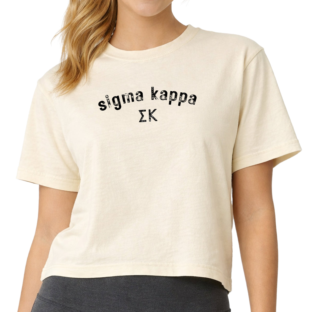 Woman wearing a Sigma Kappa Comfort Colors boxy crop t-shirt featuring the sorority name and Greek letters design