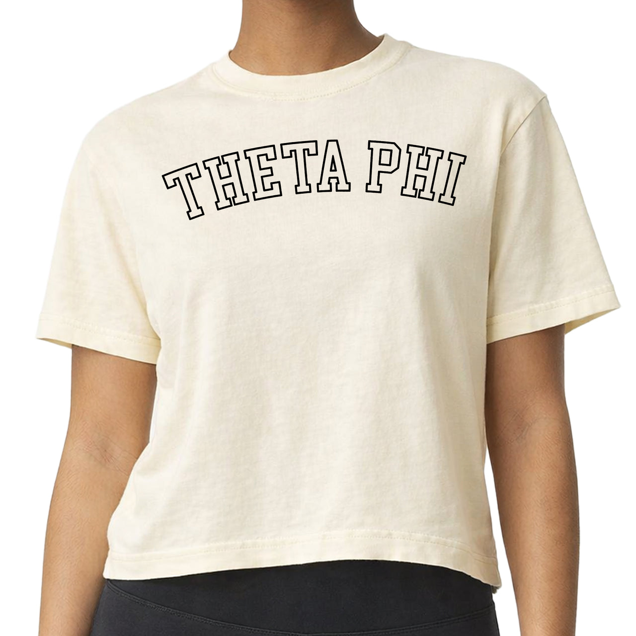 Woman wearing a Theta Phi Alpha Comfort Colors boxy crop t-shirt featuring the sorority name in block letters 