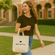 Delta Gamma small tote featuring DG letters and heart, worn over the shoulder on a sunny school day.