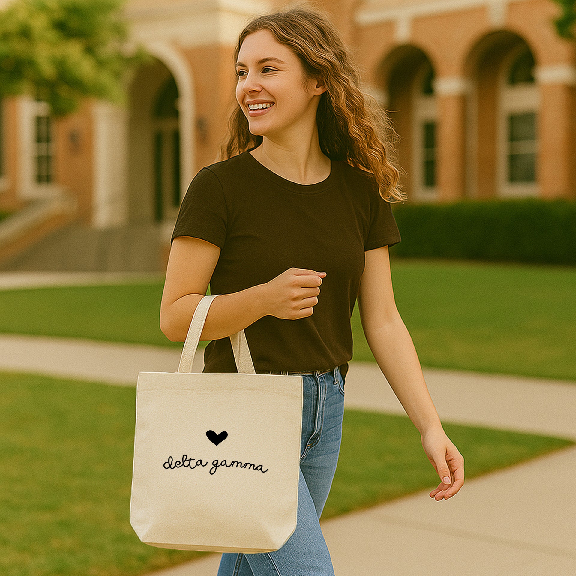 Delta Gamma small tote featuring DG letters and heart, worn over the shoulder on a sunny school day.