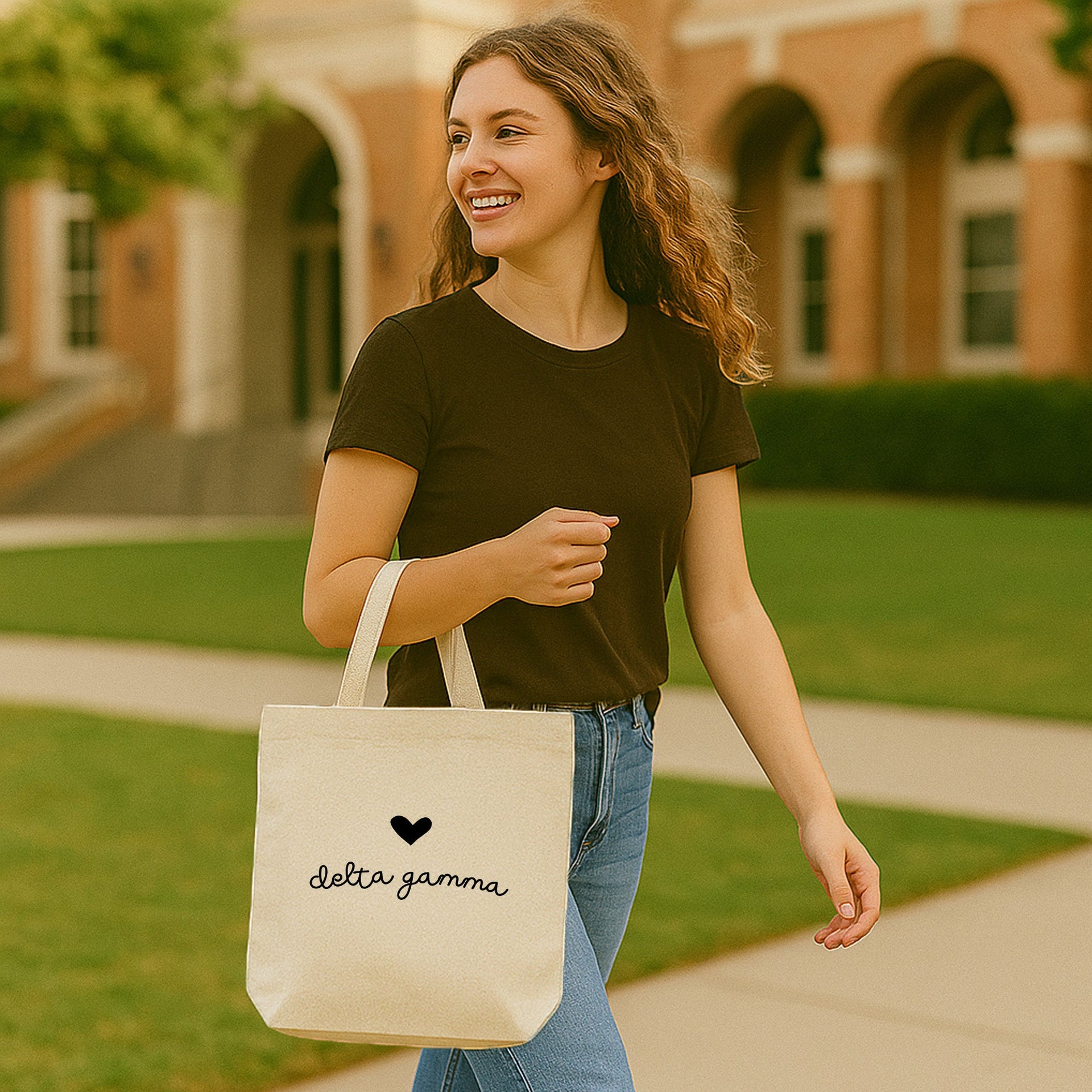 Delta Gamma small tote featuring DG letters and heart, worn over the shoulder on a sunny school day.