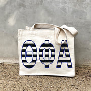 TPA Black Stripe Tote in front of a gray wall