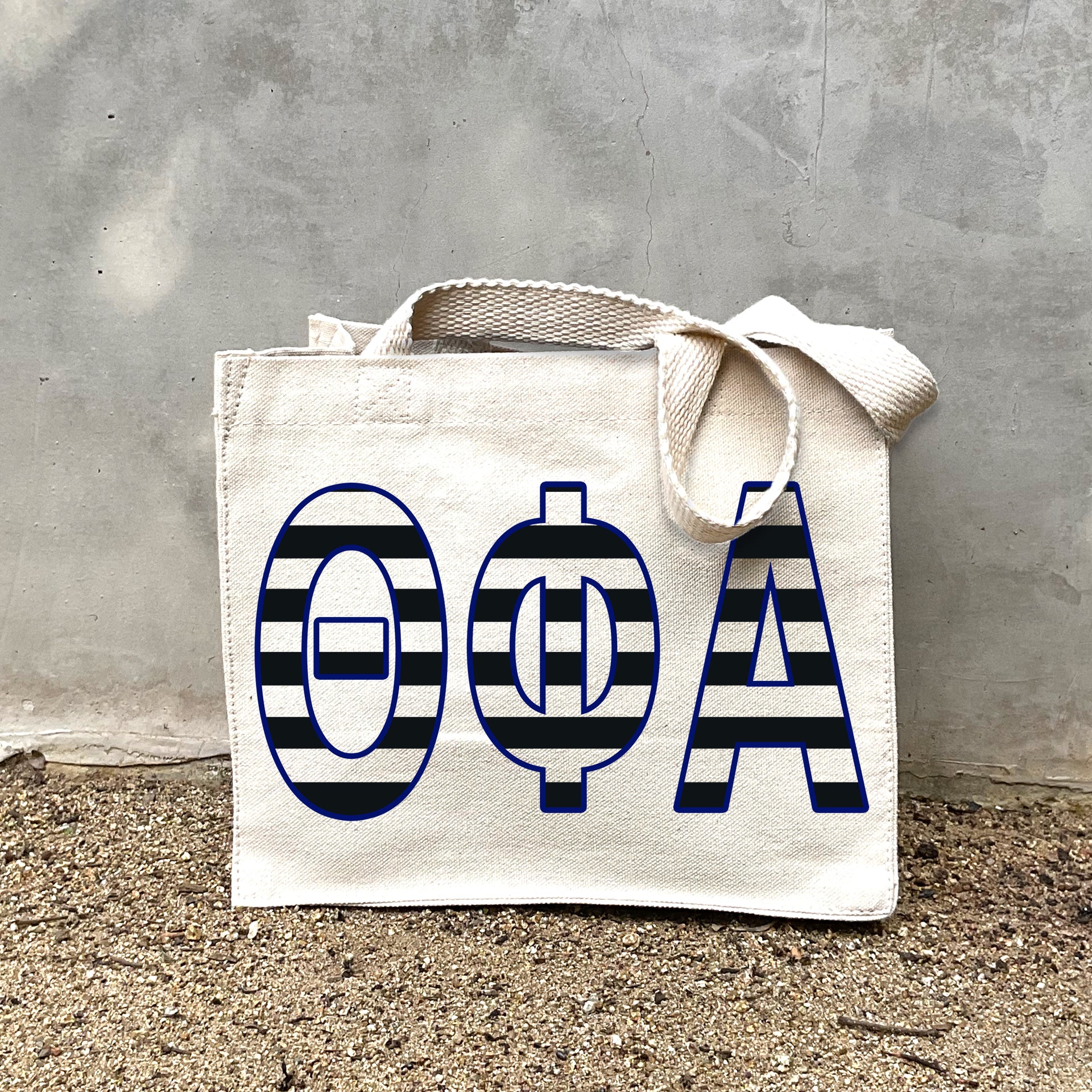 TPA Black Stripe Tote in front of a gray wall