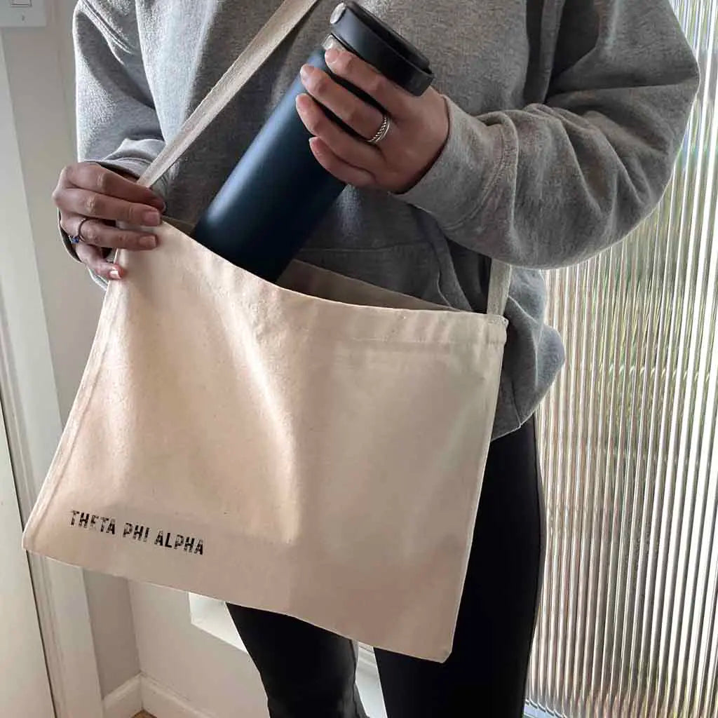 Crafted from durable canvas, each spacious bag features the Theta Phi Alpha name digitally printed on both sides in the lower corner. Perfect for all your essentials, this carry-all silhouette is a fantastic gift idea and a favorite for chapter orders and big-little gifts