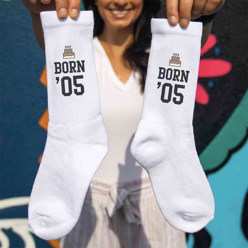 Born and your year design printed on white cotton crew socks with a gift wrap box included.