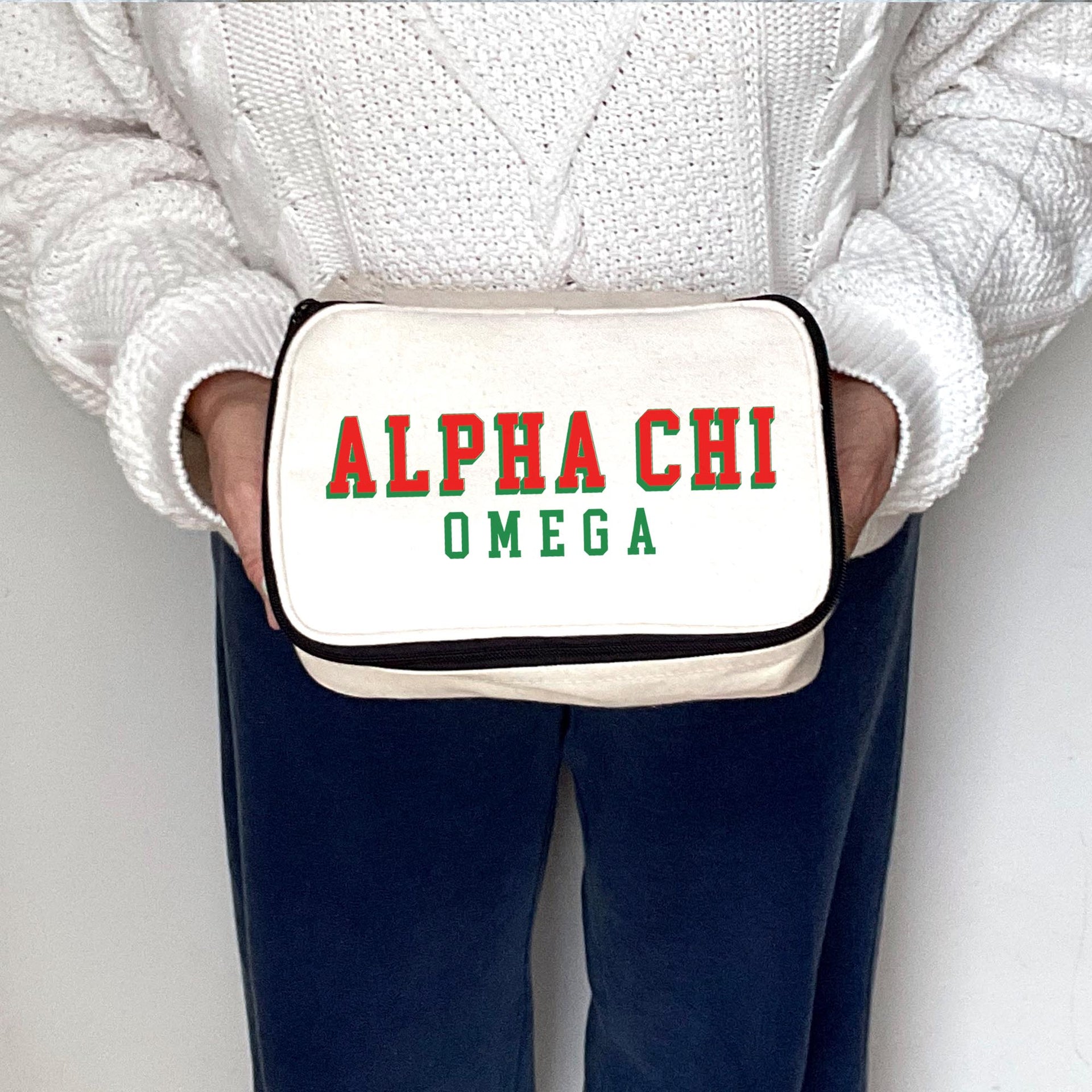 Sorority woman holding an Alpha Chi Omega sorority cosmetic travel bag.